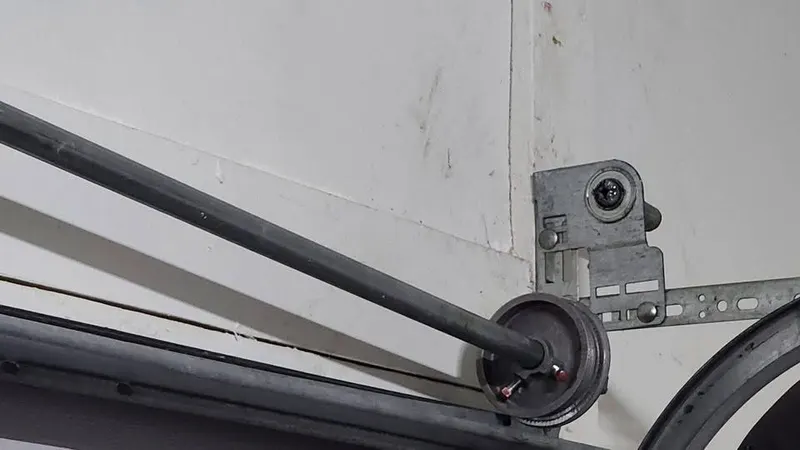 Garage door cable drum on the torsion shaft next to the end bearing plate